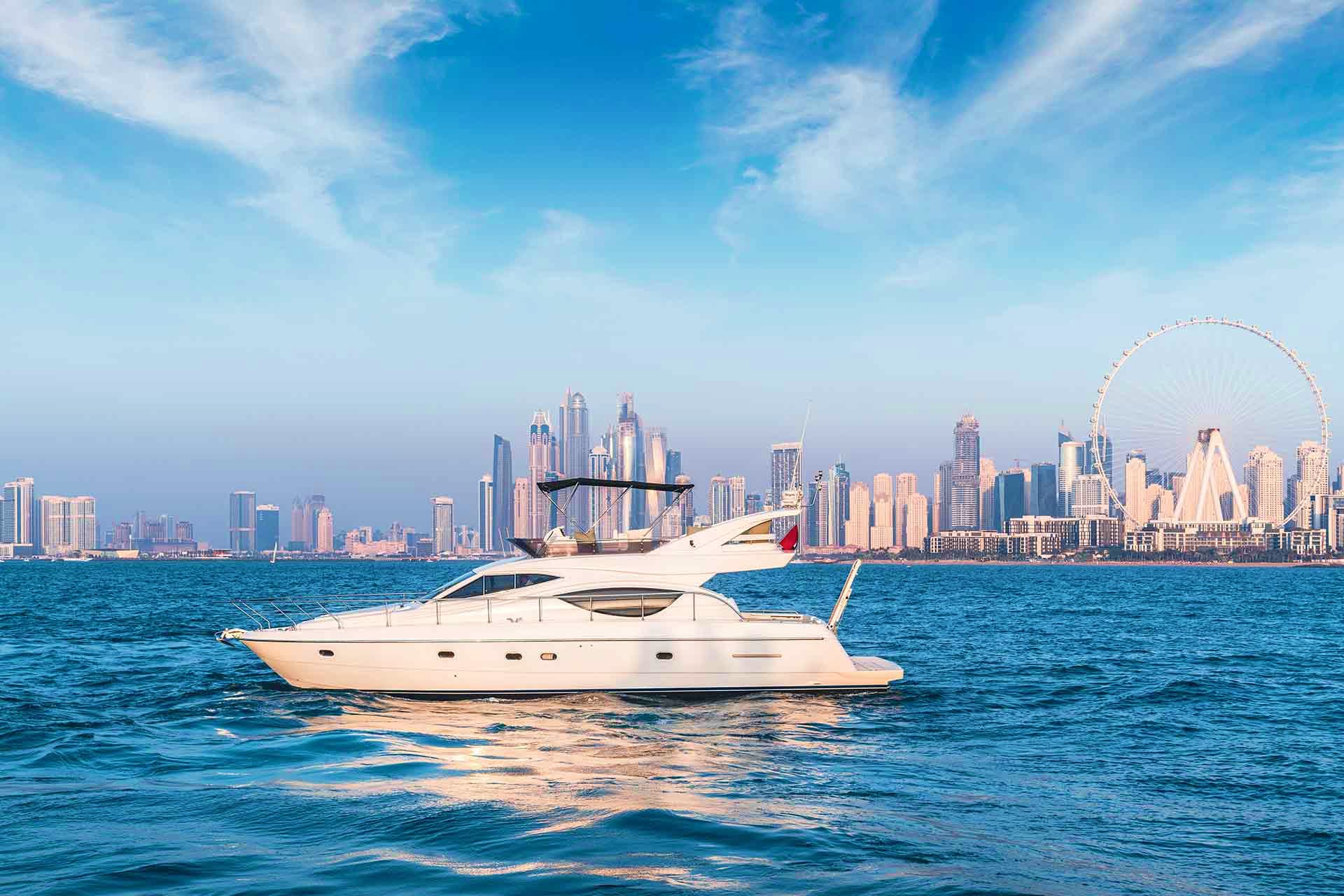 Luxury yacht anchored in blue sea with Dubai skyline and Ferris wheel in background